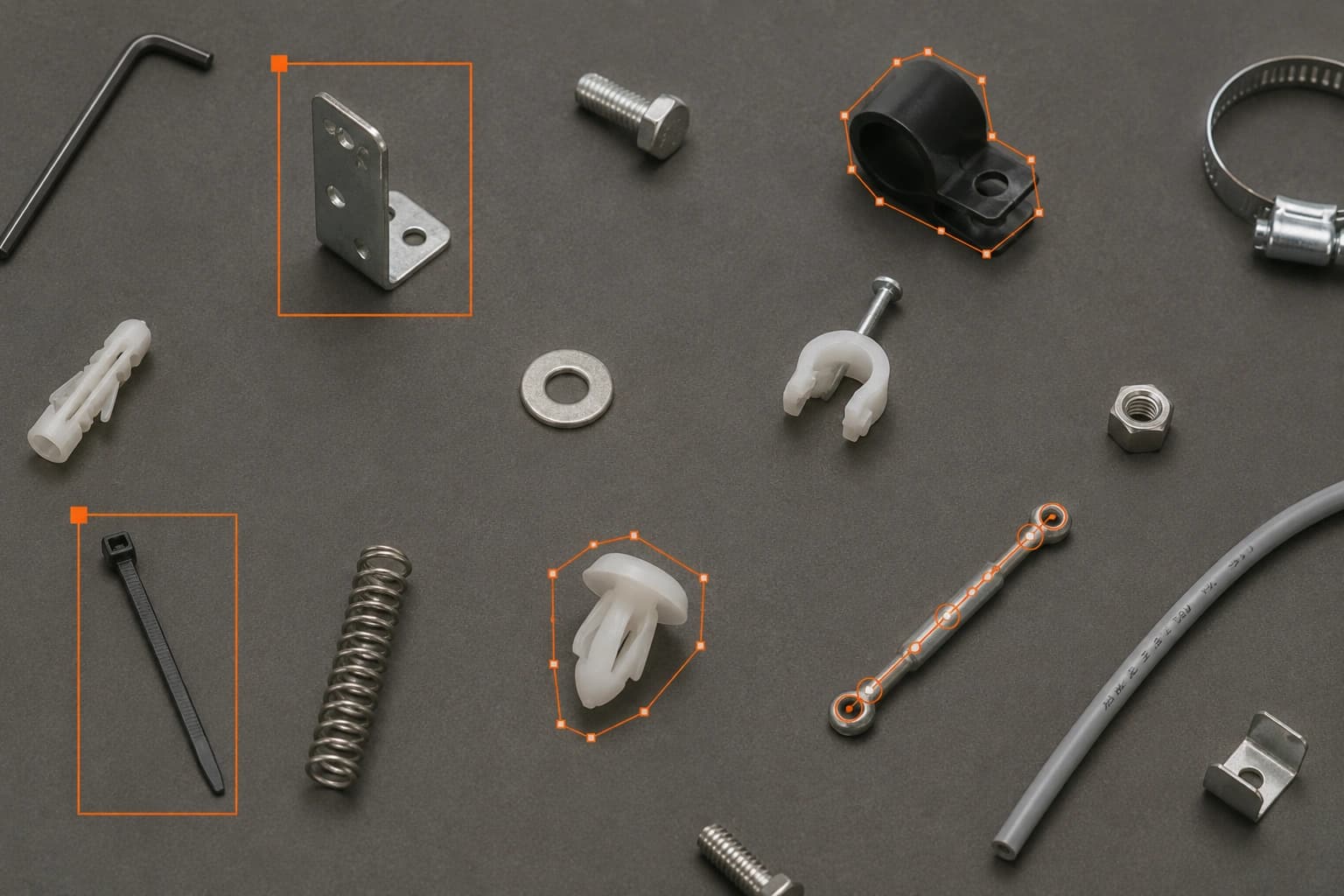 Small hardware parts on a table, several boxed with orange bounding-box labels